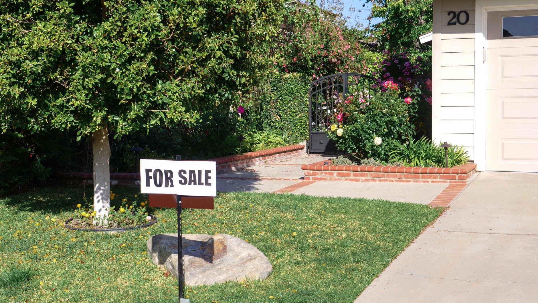 Real estate bailout - for sale sign on green grass lawn